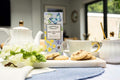 Tea set with cookies and a box of Farmhouse Biscuits on a table.