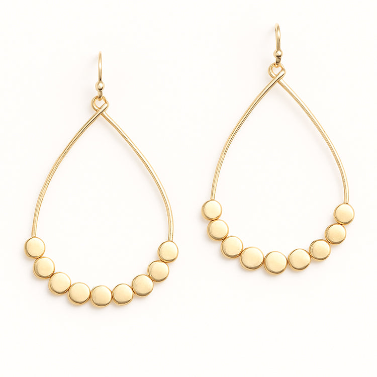 Gold hoop earrings with bead embellishments on a white background