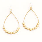 Gold hoop earrings with bead embellishments on a white background