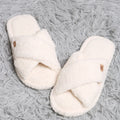 Pair of white slippers on a textured gray surface