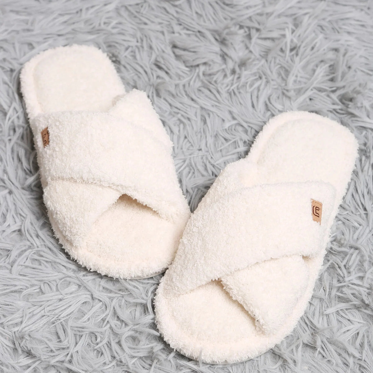 Pair of white slippers on a textured gray surface