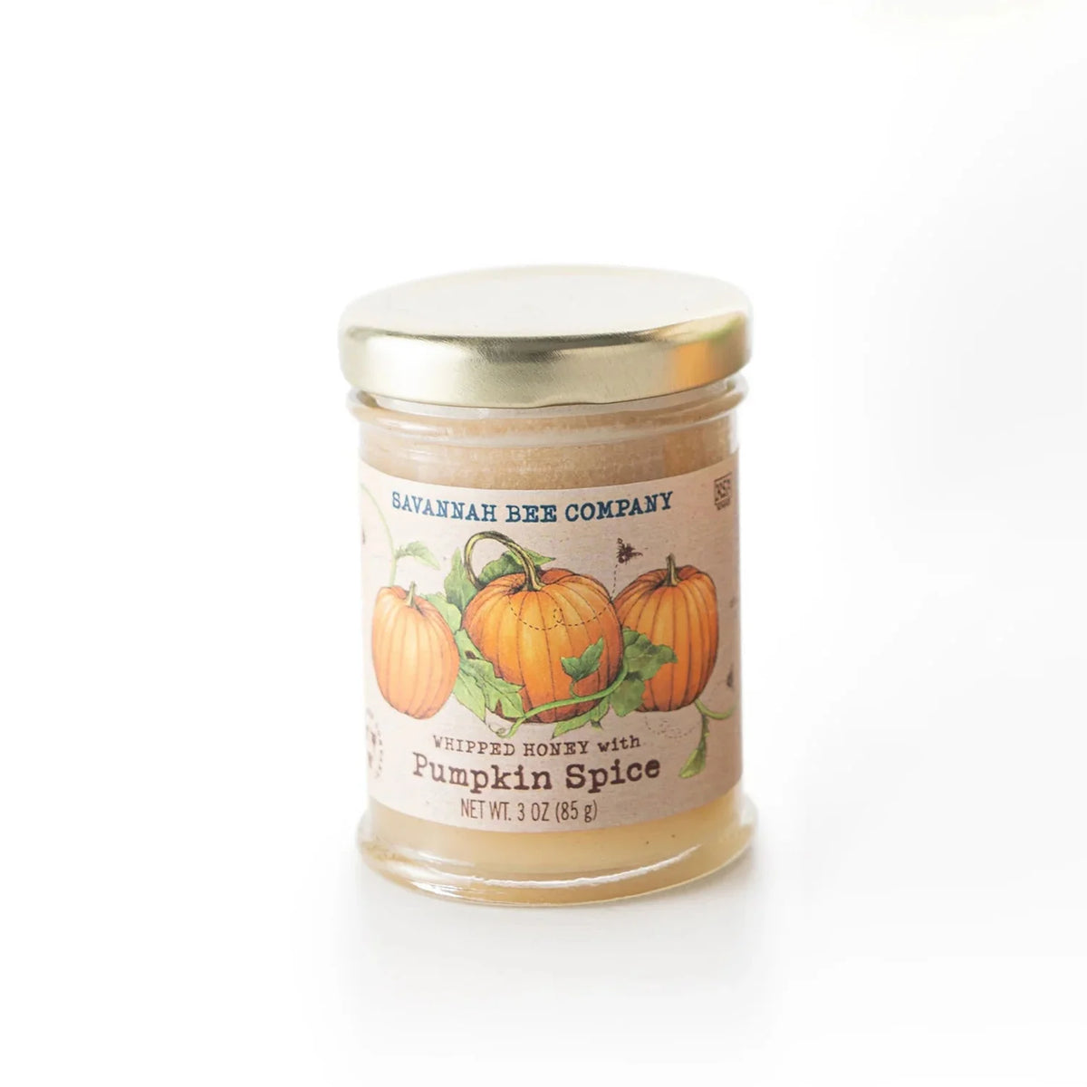 A glass jar candle with a gold metal lid and a vintage-style label featuring pumpkins, labeled 'Bayshore Bee Company Whipped Breeze with Pumpkin Spice'.